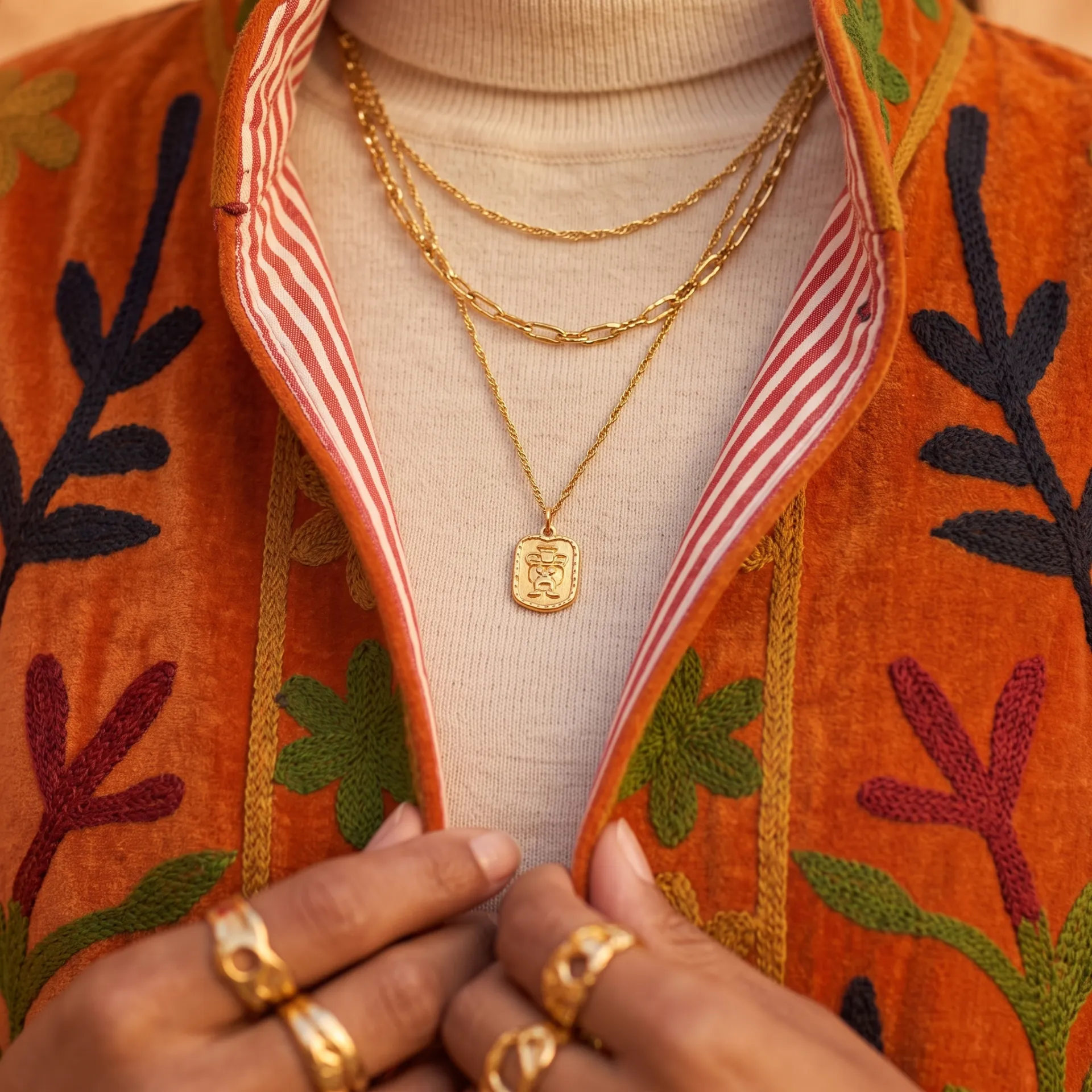 Detalle del bordado floral hecho a mano Kantha y solapa interior a rayas en chaqueta terciopelo de color naranja Modamiomio